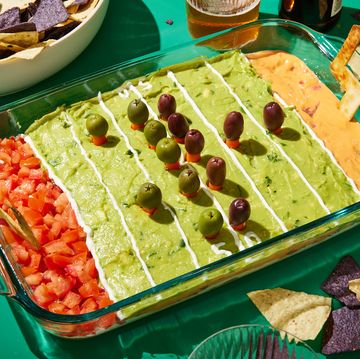 football field decorated layered dip with refried beans, sour cream, pico de gallo, guacamole, and queso