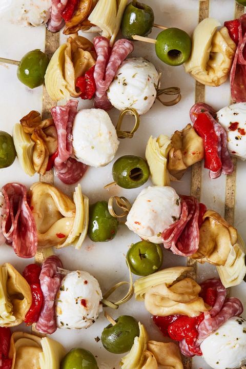 antipasto bites with green olives, cheese balls, tortellini, and salami on skewers