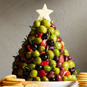 cheese ball shaped like a christmas tree and covered in olives and rosemary