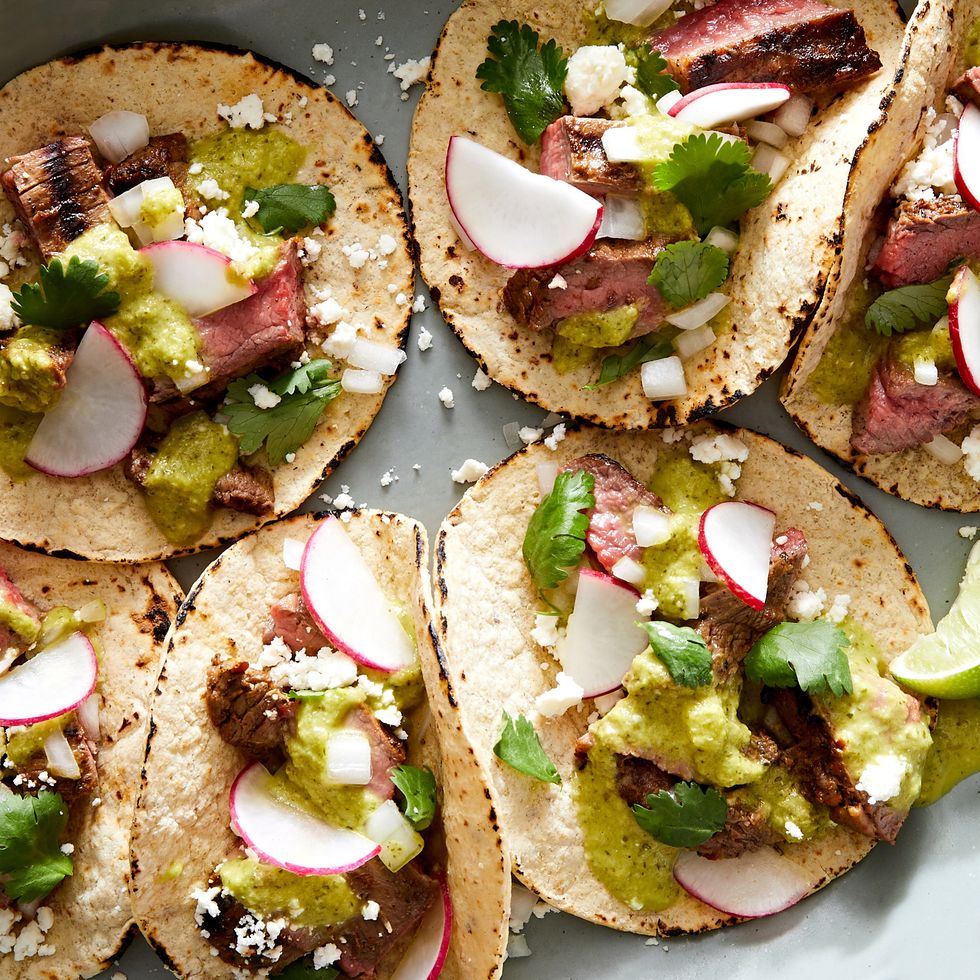 marinated, grilled skirt steak, piled into a corn tortilla with salsa verde, cilantro, red onion, cotija, and radish