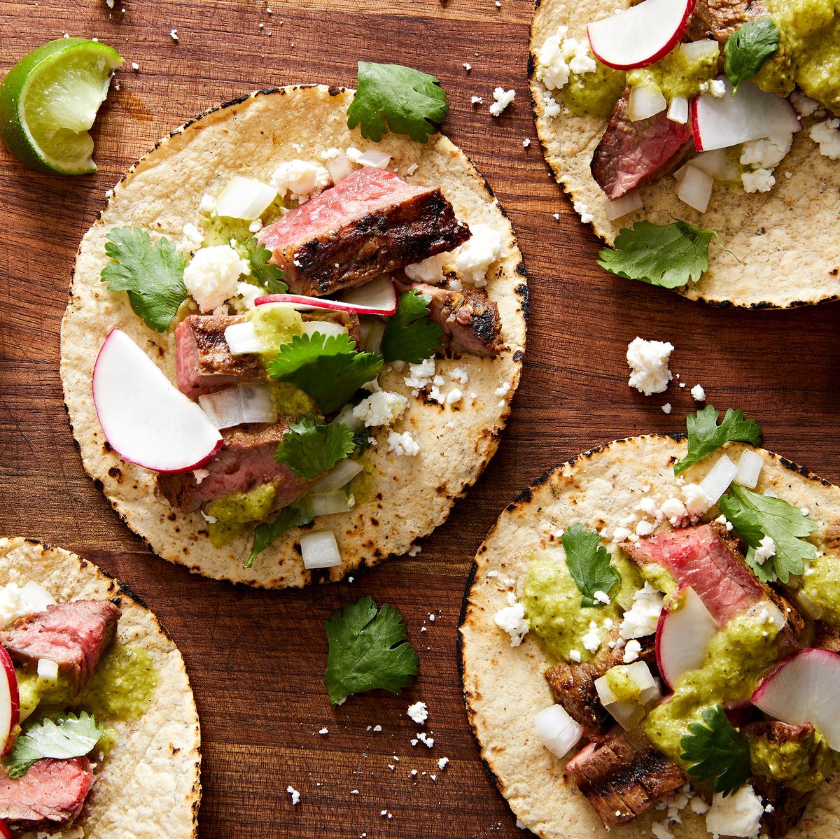 marinated, grilled skirt steak, piled into a corn tortilla with salsa verde, cilantro, red onion, cotija, and radish