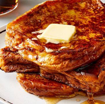 a stack of french toast on a white plate topped with butter and maple syrup