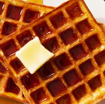 square classic waffles topped with butter and drizzled with maple syrup