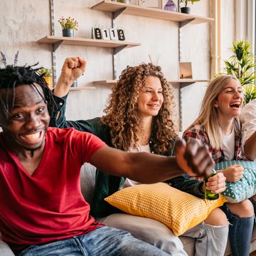 excited fans cheering for sport team watching american football game