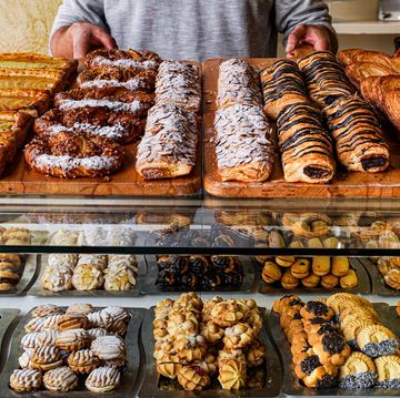 man dispensing cakes in a pastry bakery