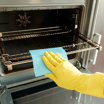 Man with rag and rubber gloves cleaning kitchen stove man with rag and rubber gloves cleaning kitchen stove