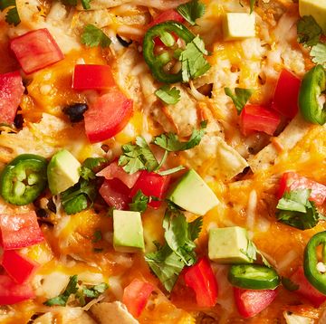 mexican chicken casserole topped with diced tomatoes, jalapenos and avocado