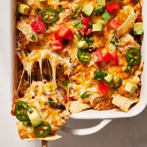 mexican chicken casserole topped with diced tomatoes, jalapenos and avocado