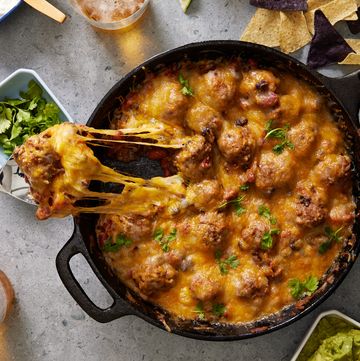 chili and meatballs in a cast iron skillet, topped with melty cheese