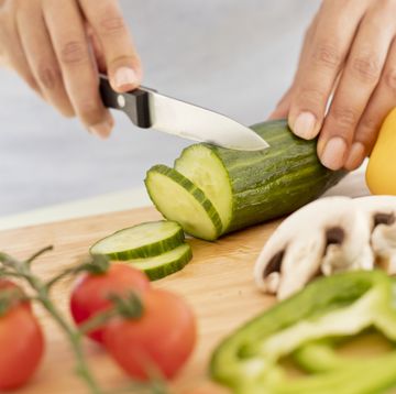 woman chopping fresh cucumber