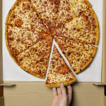 Young woman taking slice of pizza, overhead view